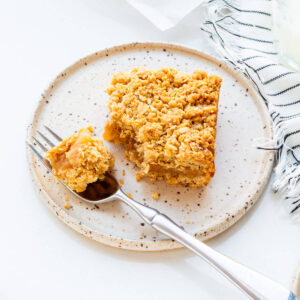 Apple crumble bar with oat topping on a plate.
