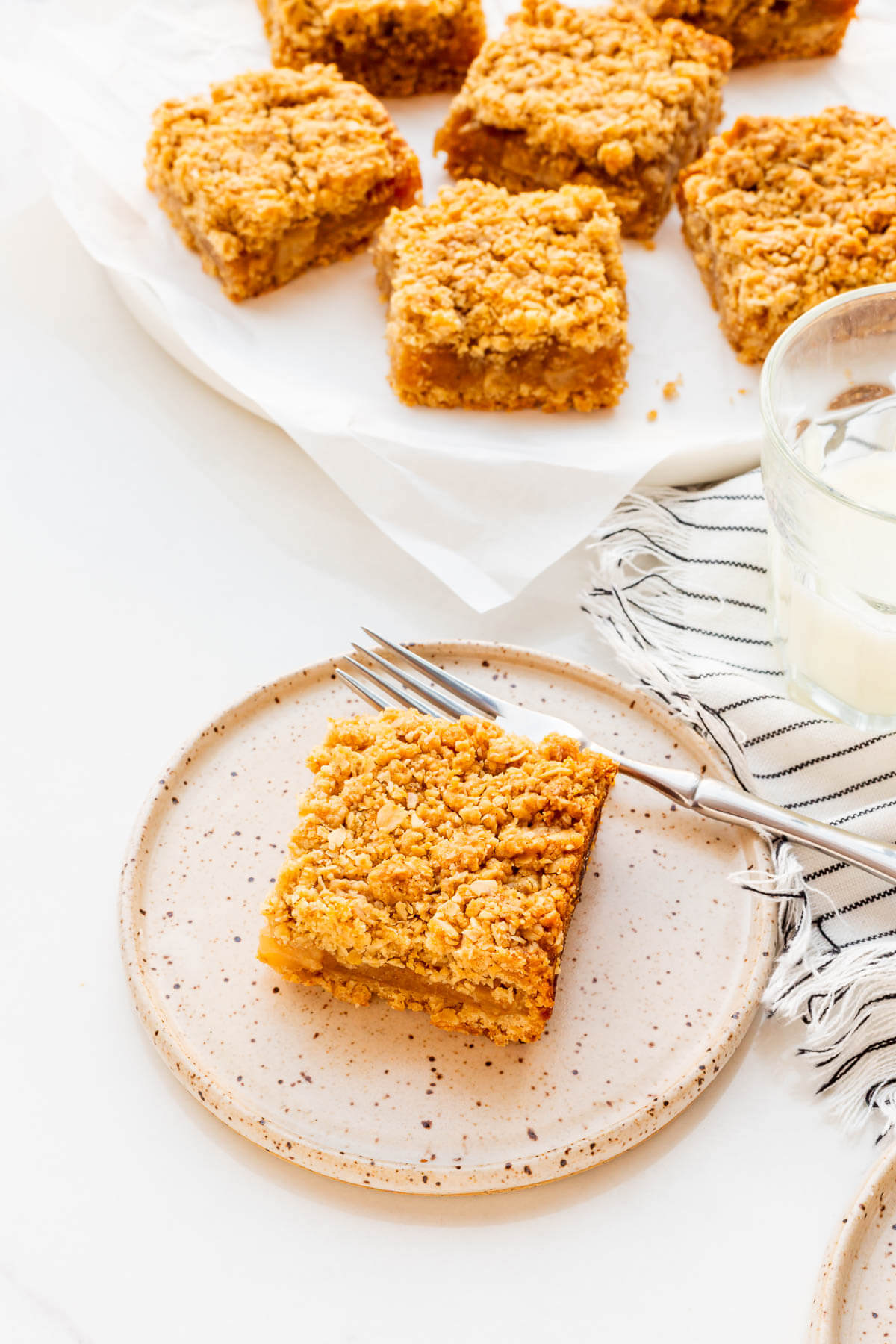 Apple pie bars topped with an oat crumble being served.