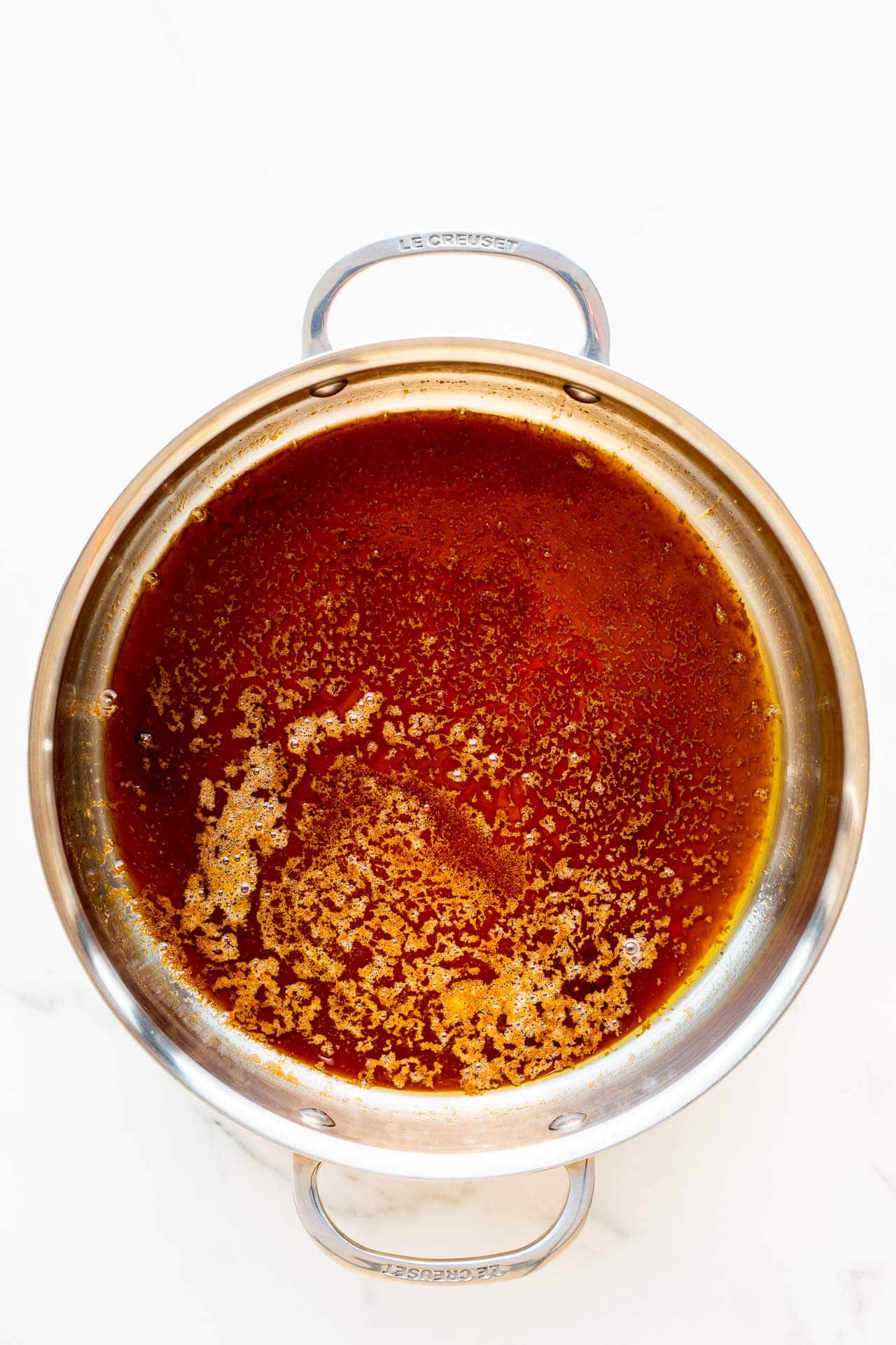 Dry caramel made from sugar in a 10 inch stainless steel pan