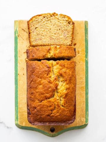 Banana bread sliced on a cutting board.