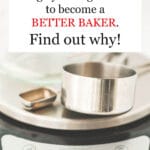 A kitchen scale with a stainless dry measuring cup, a measuring teaspoon, and a glass Pyrex liquid measuring cup