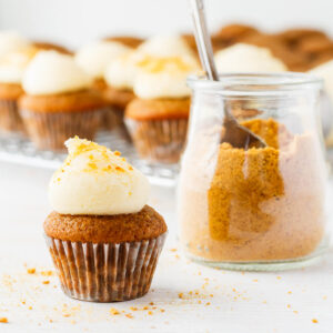 Apple cupcakes with cream cheese frosting on top and graham cracker crumbs.