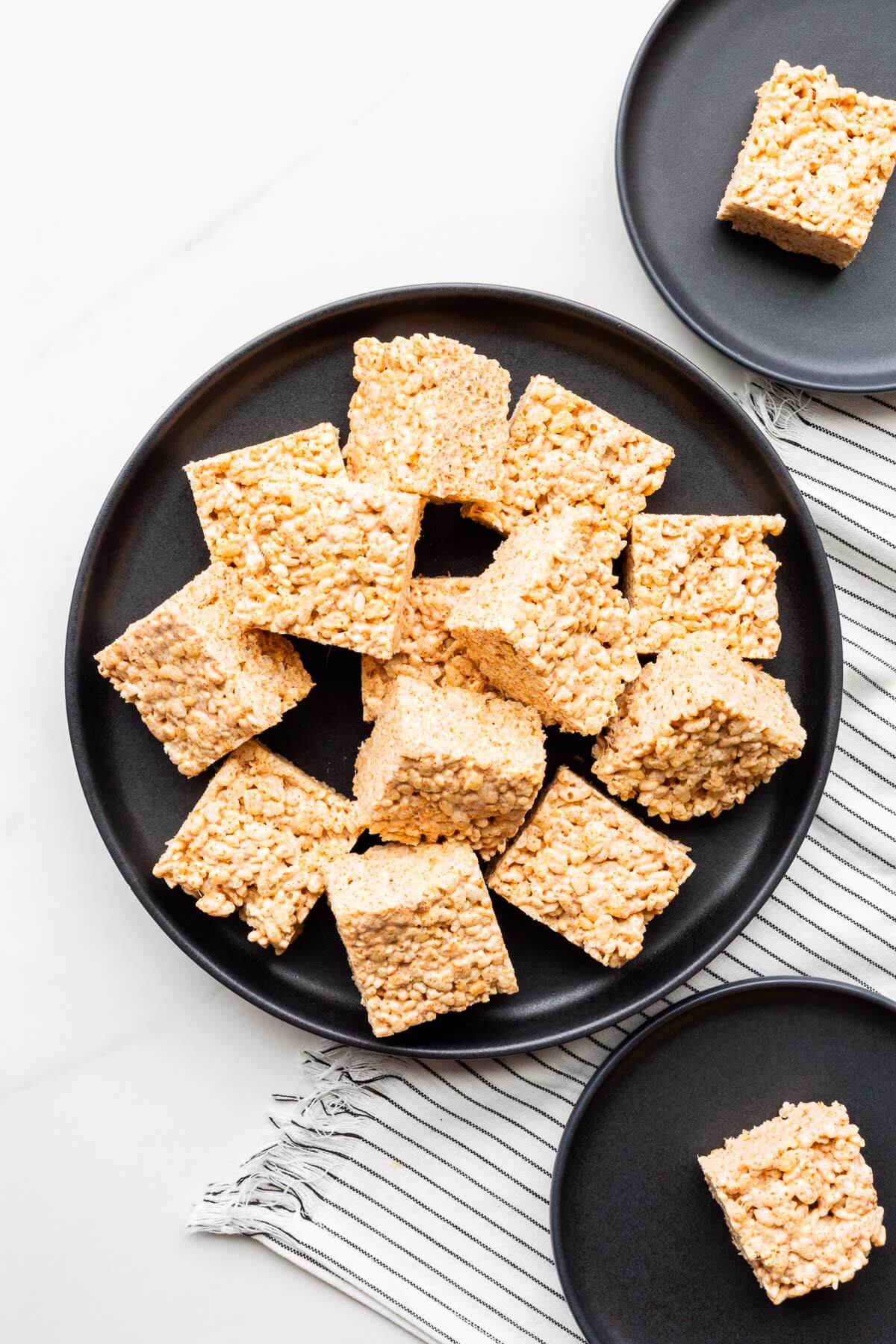 A plate of Rice Krispie treats cut into squares being served.