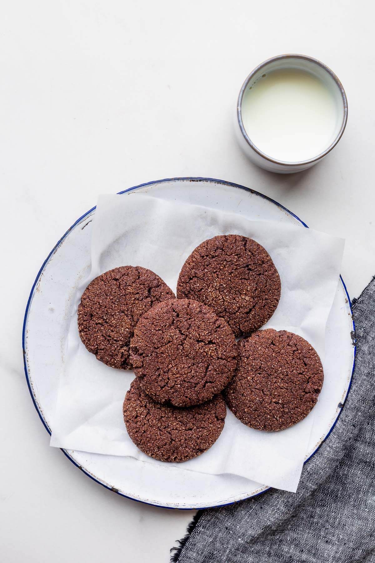 A plate of chocolate snickerdoodle cookies served with a glass of milk.