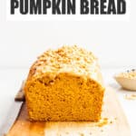 A loaf of glazed maple pumpkin bread on a cutting board.