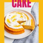 A lavender honey cake topped with whipped cream being sliced on served.