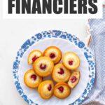 A floral plate of raspberry almond financiers with a striped napkin.