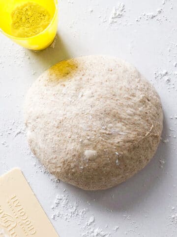 Pre-shaping bread dough to make a sourdough boule in a Dutch oven.