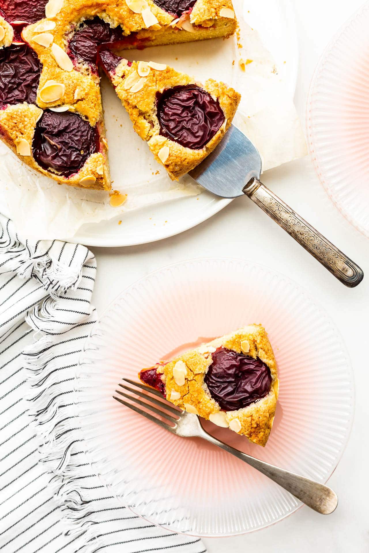 Serving fresh plum cake on dessert plates.