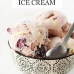 Cherry bourbon ice cream scooped in a black and white bowl and served with a spoon