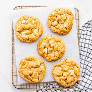 White chocolate macadamia cookies on a cooling rack.