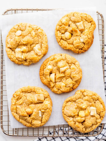 White chocolate macadamia cookies on a cooling rack.