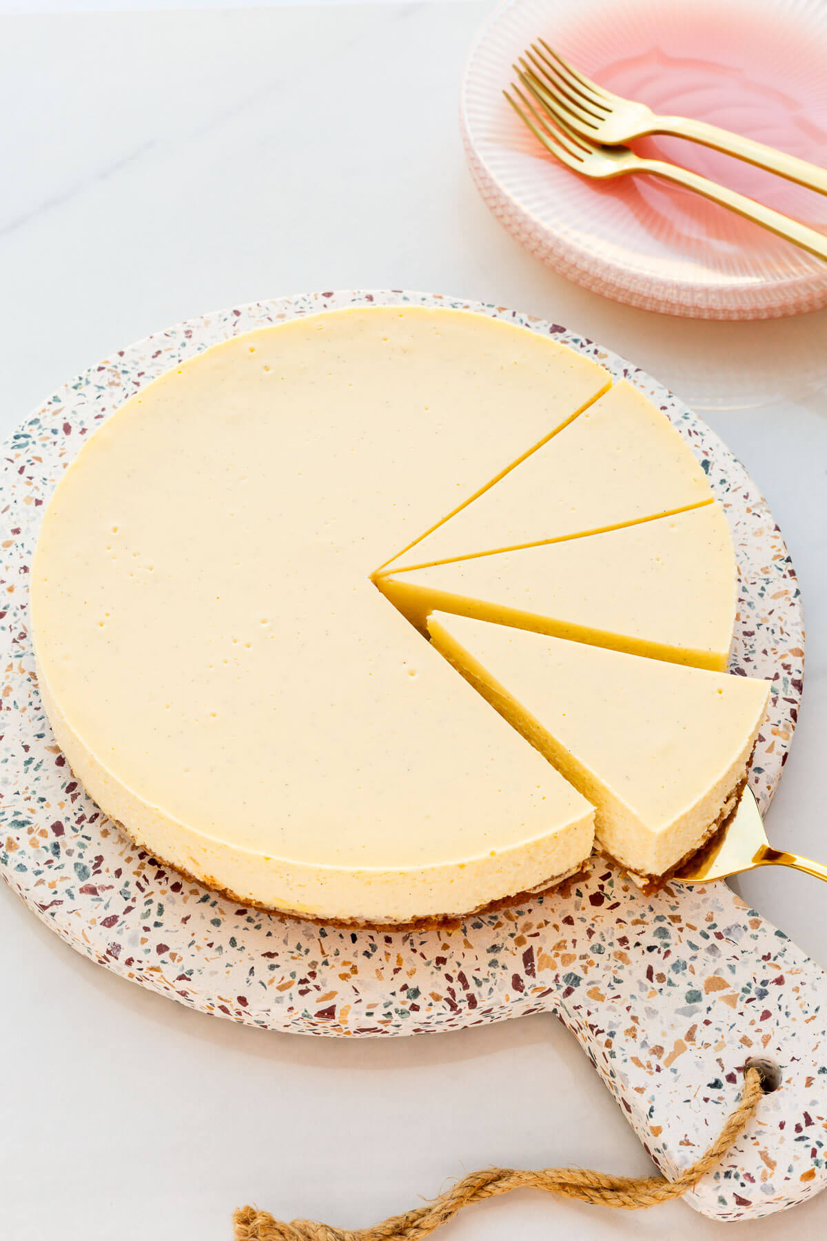 A vanilla cheesecake being sliced to serve it.