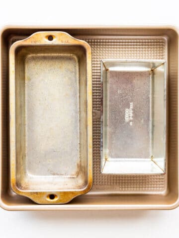 A stack of cake pans, one square and two rectangular loaf pans of different sizes.