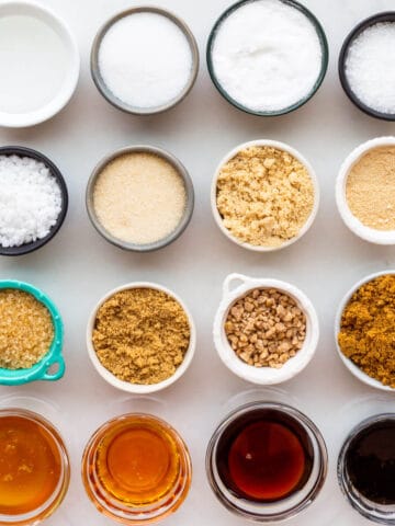 Small bowls of sixteen different sugars to show the difference in texture and colour of each of them.