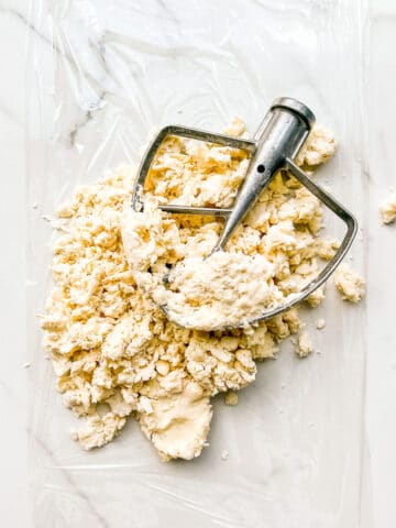 Shaggy pie dough on a piece of plastic wrap to gather it into a disk and wrap it to chill.