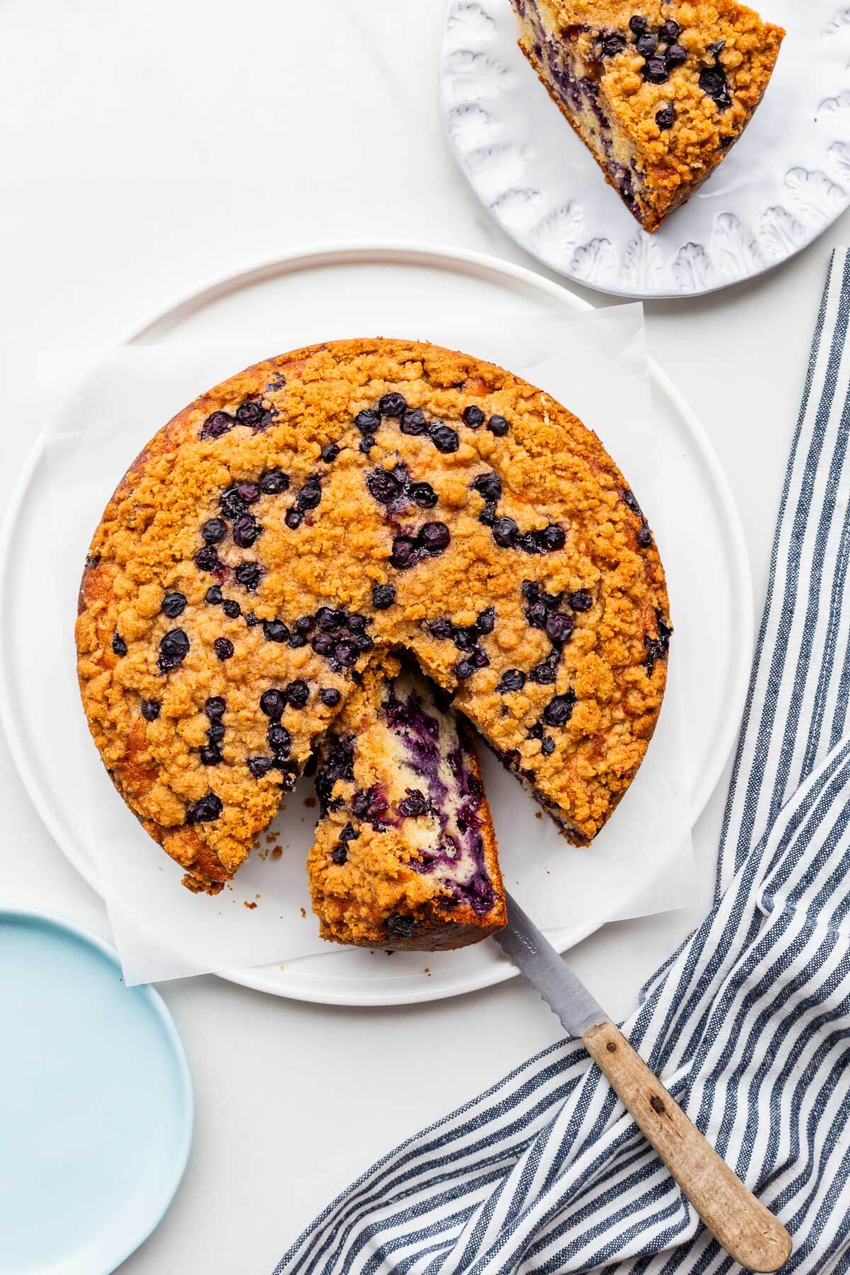 Slicing and serving a blueberry coffee cake.