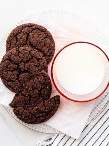A plate of chocolate sugar cookies and a glass of milk.