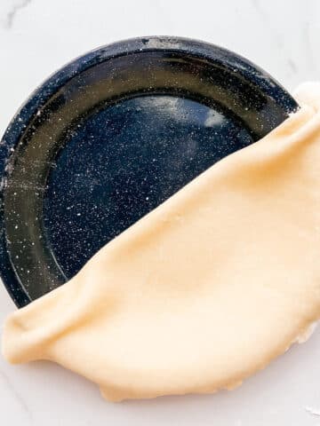 Transferring pie dough to a pie plate to make a pie crust.