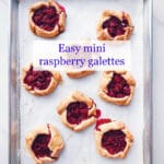 mini raspberry galette pies cooling on a parchment-lined baking sheet