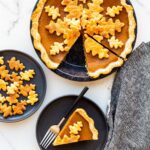 Serving pumpkin pie on black plates.