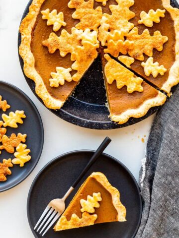 Serving pumpkin pie on black plates.