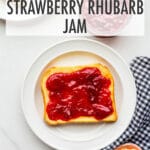 Homemade strawberry rhubarb jam spread on a piece of toast, with butter on the side.