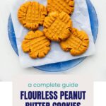 A blue plate of peanut butter cookies with a criss-cross pattern on them.