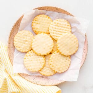 A pink plate filled with lemon shortbread cookies and with a yellow napkin.