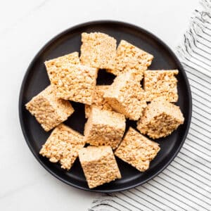 A plate of puffed rice and marshmallow treats cut into squares.