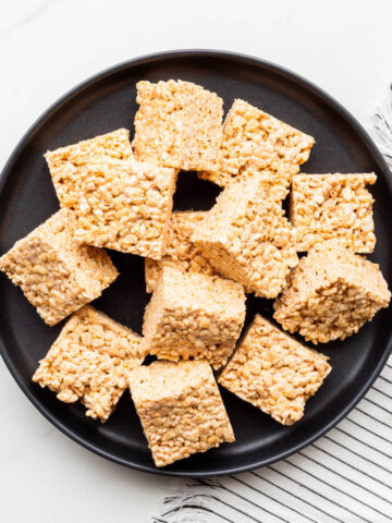 A plate of puffed rice and marshmallow treats cut into squares.