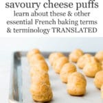 A baking sheet of baked gougères (cheese puffs) lined with parchment