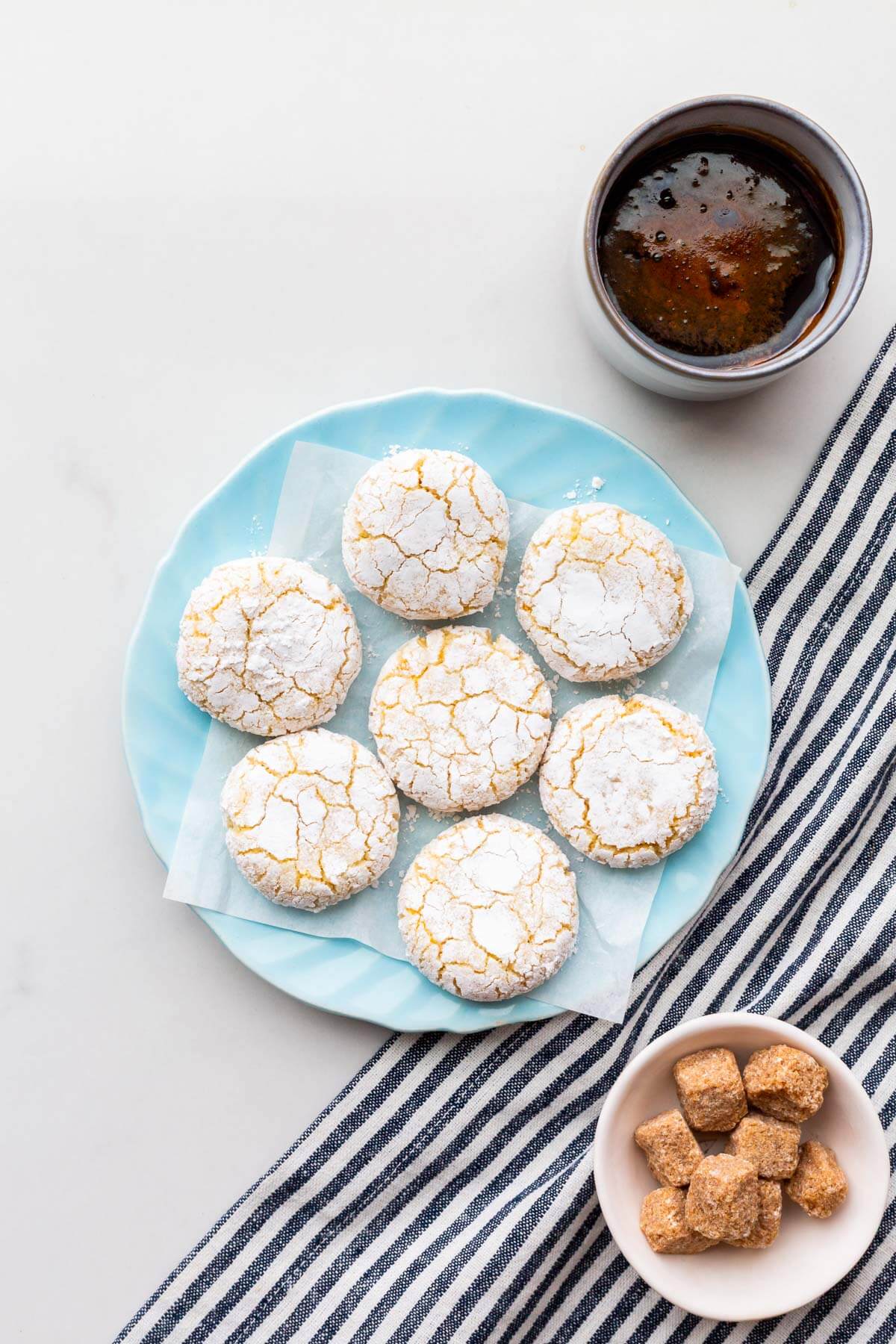 A plate of amaretti cookies served with a cup of coffee.