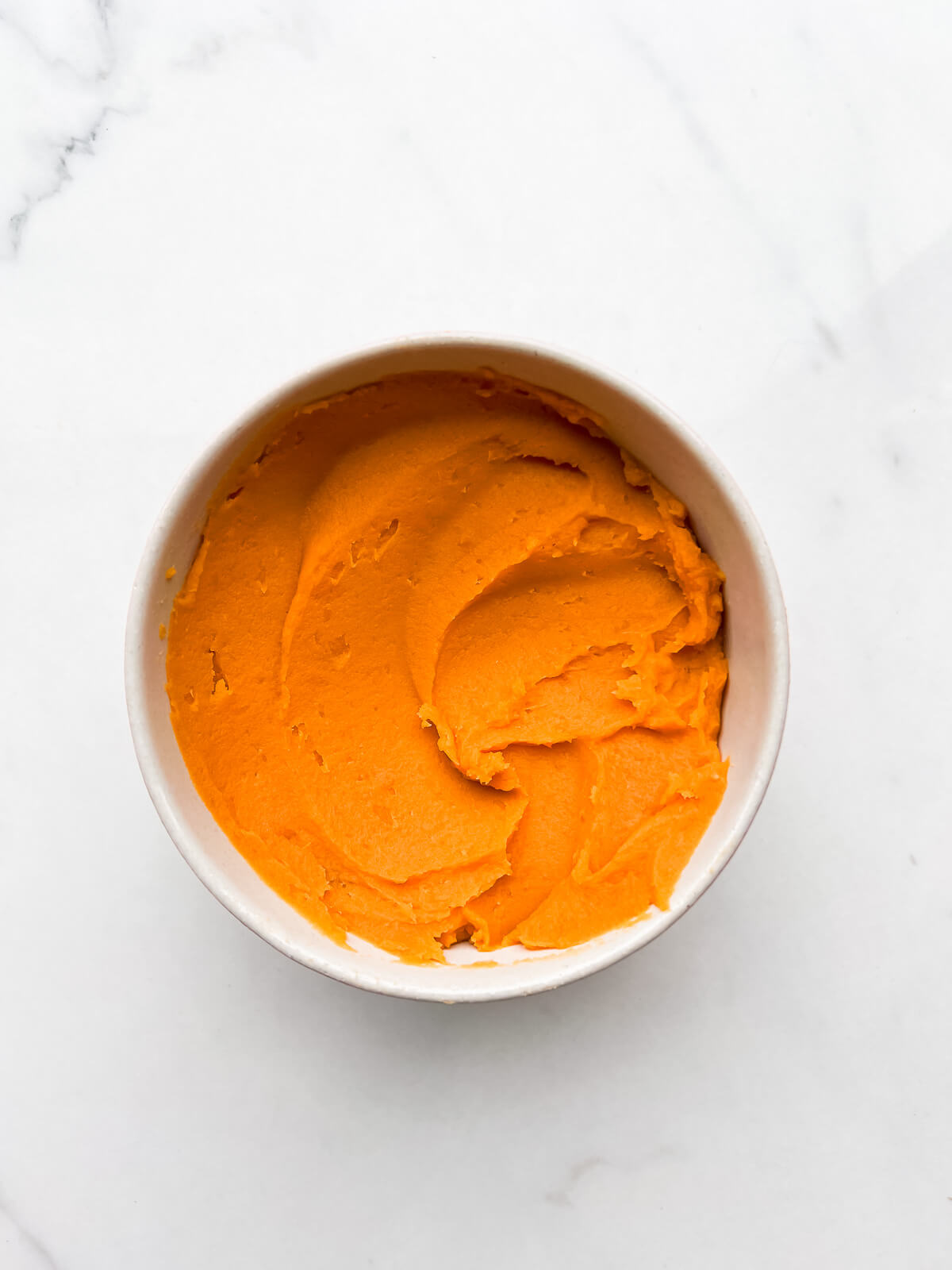 A bowl of smooth sweet potato purée for making pies.