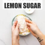 Rubbing lemon zest into granulated sugar with fingertips in a bowl to make lemon sugar.