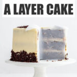 A layer cake on a cake stand, with parchment paper pressed up on the cut sides of the cake to help prevent drying.