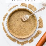 A tart pan with tart dough fitted inside and a fork to prick the pastry to allow air and steam to escape during blind baking