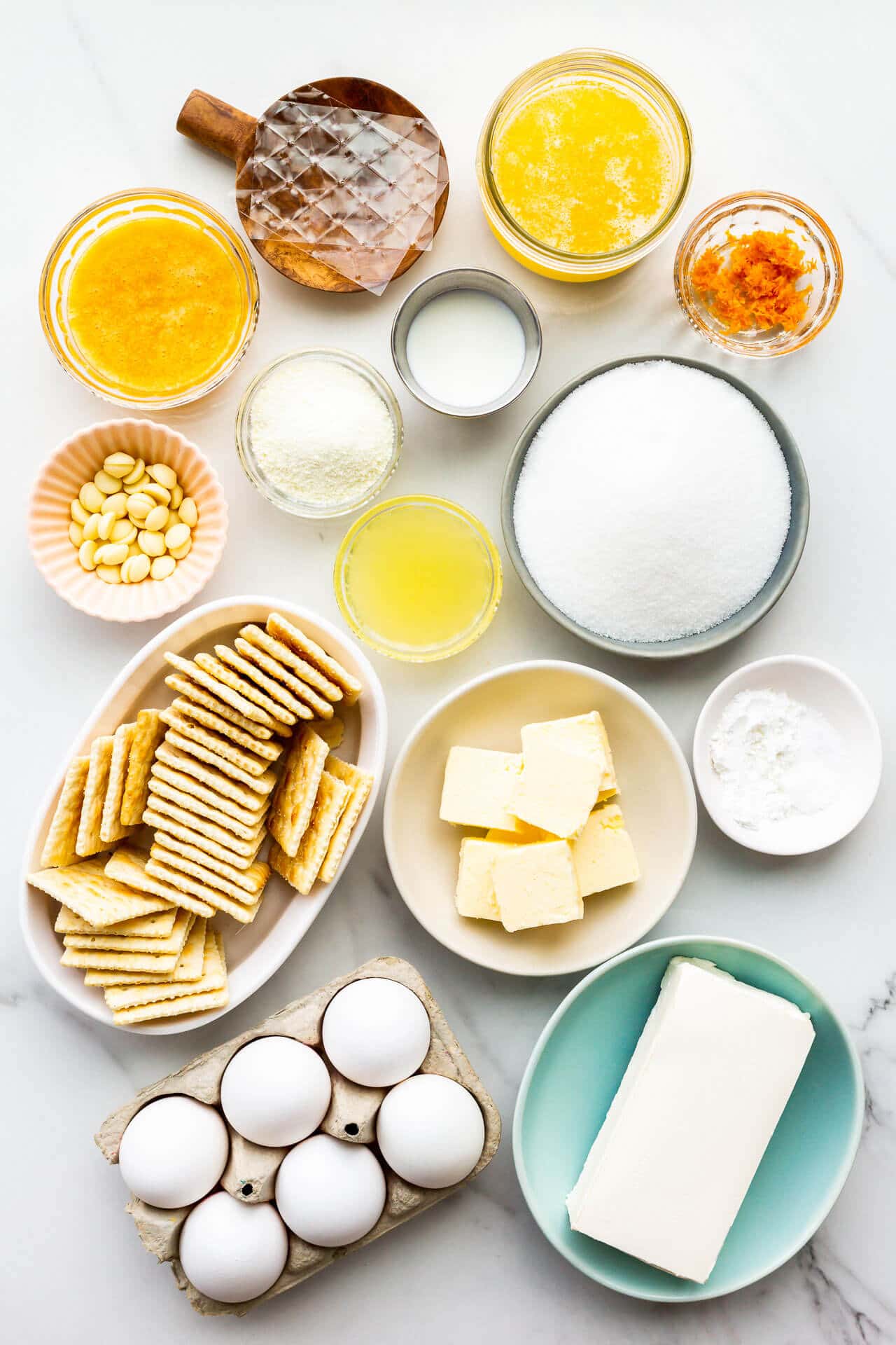 Ingredients to make orange pie with orange curd, liquid cheesecake filling, and saltine crust measured out and ready to be mixed.