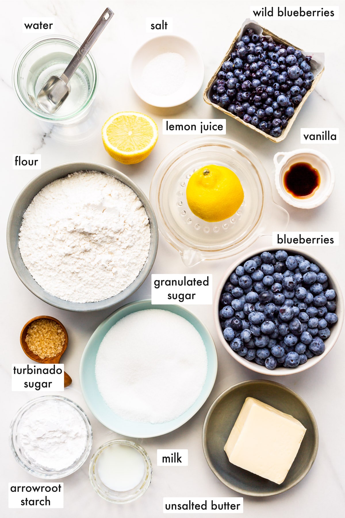 Ingredients to make blueberry pie from scratch with fresh and wild blueberries.