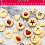 jam filled shortbread cutout cookies that hold their shape sandwhiched with strawberry jam and a bowl of jam with a spoon