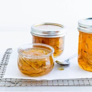 Jars of homemade lime marmalade on a cooling rack.