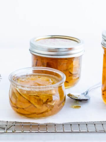 Jars of homemade lime marmalade on a cooling rack.