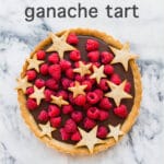 Milk chocolate ganache tart made with a coffee cookie crust and topped with raspberries and cookie stars