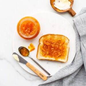 Homemade thick cut orange marmalade spread on toast with butter.