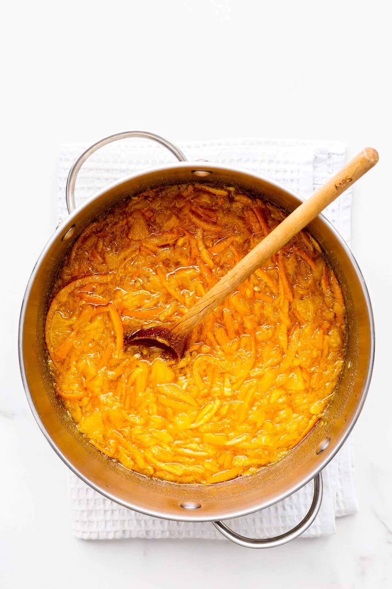 A pot of sliced oranges and sugar, ready to be boiled to make homemade orange marmalade.