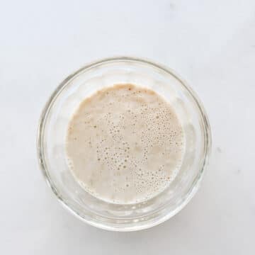 A glass of proofed yeast made by mixing yeast with water and a little sugar, letting it sit until it is foamy and active.