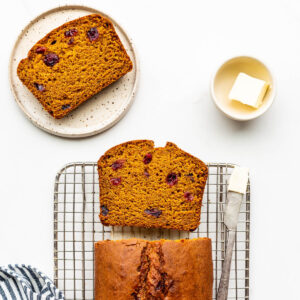 Slicing and serving a pumpkin bread with cranberries.