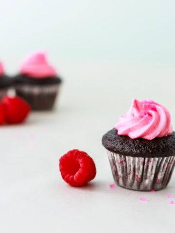 A dark chocolate cupcake with pink frosting swirl.