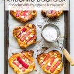 Slices of bostock, which is brioche bread topped with frangipane and rhubarb, baked in the oven until golden brown then dusted with powdered sugar