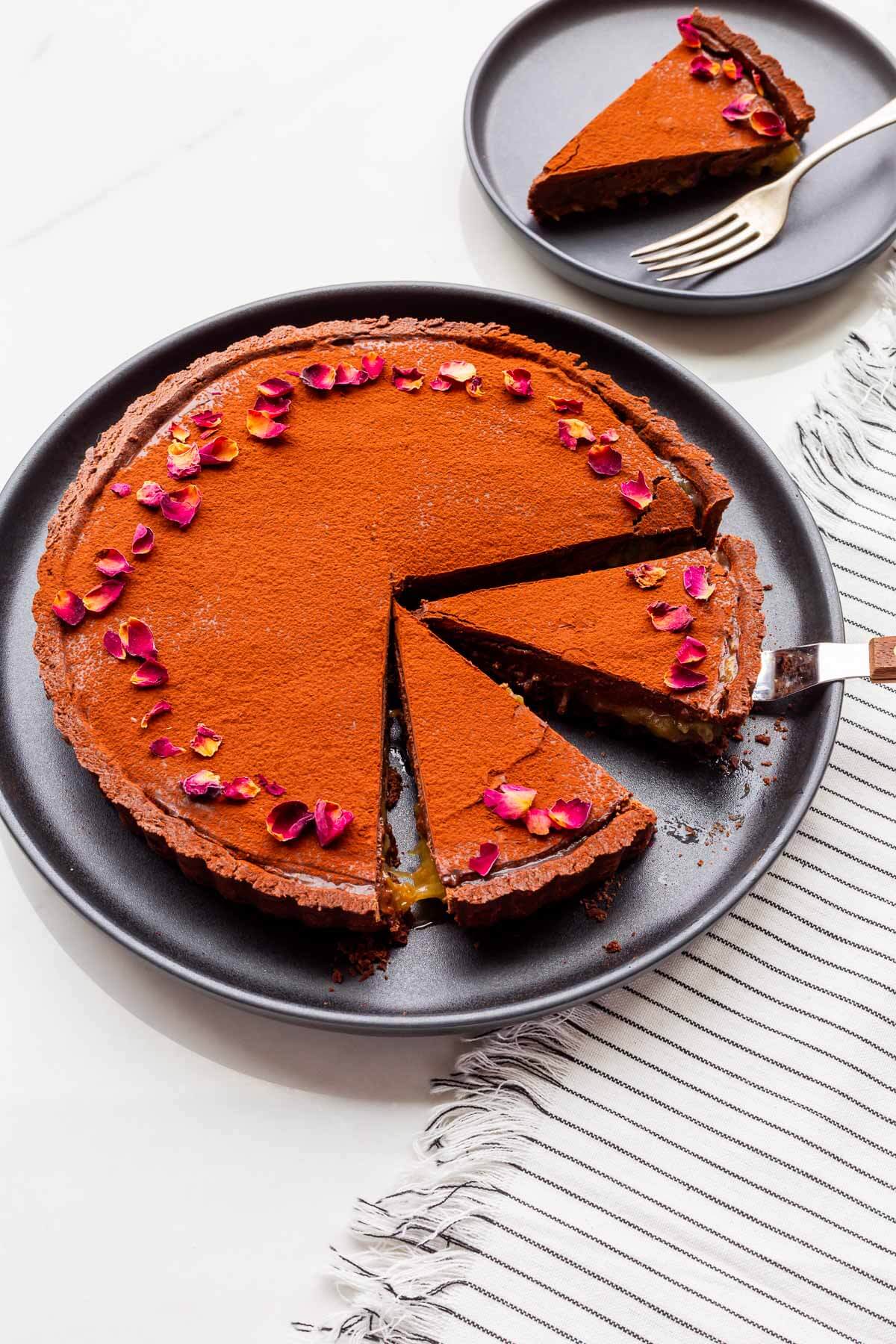 Slicing and serving a chocolate tart with rhubarb compote.